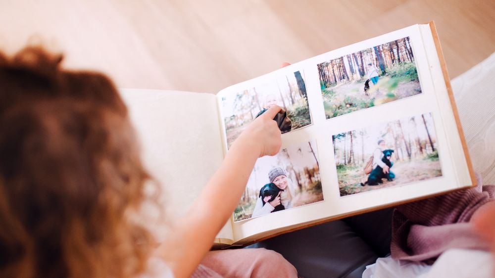 A child pointing at a printed family photo album
